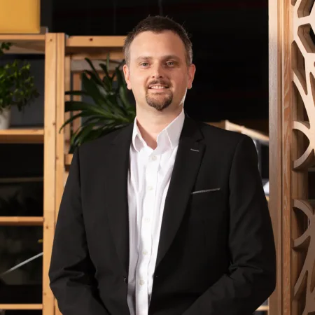 Gary Dodds standing in front a wall with an arabic ornament design in the Cundall Doha office