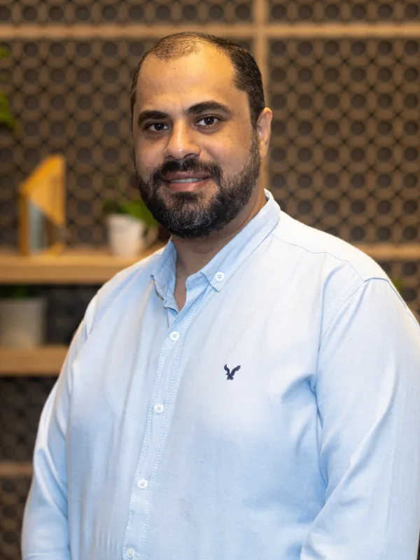 Mina Zachary in a light blue Oxford shirt against a wood textured office background