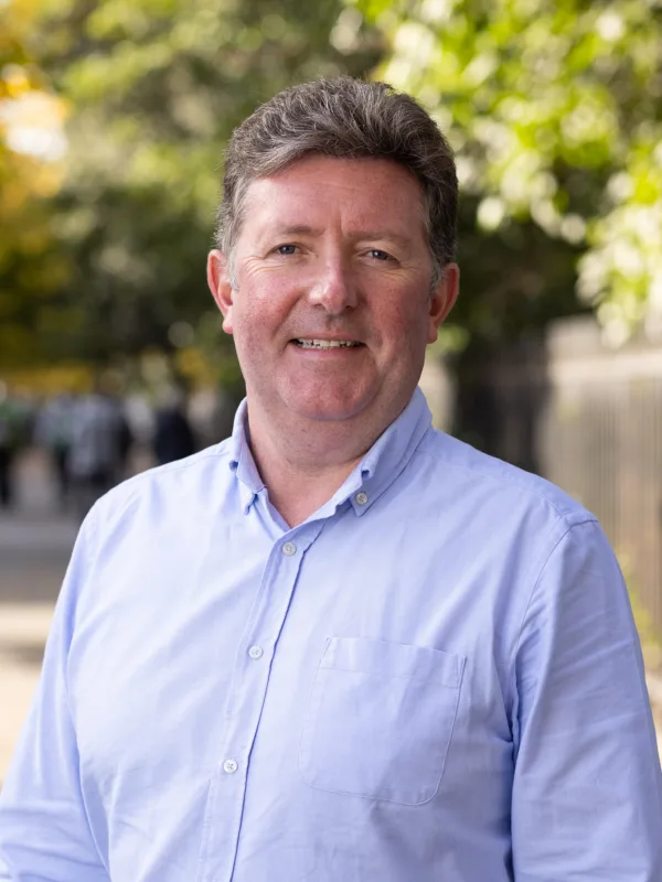 William Dolan standing outside wearing a blue shirt