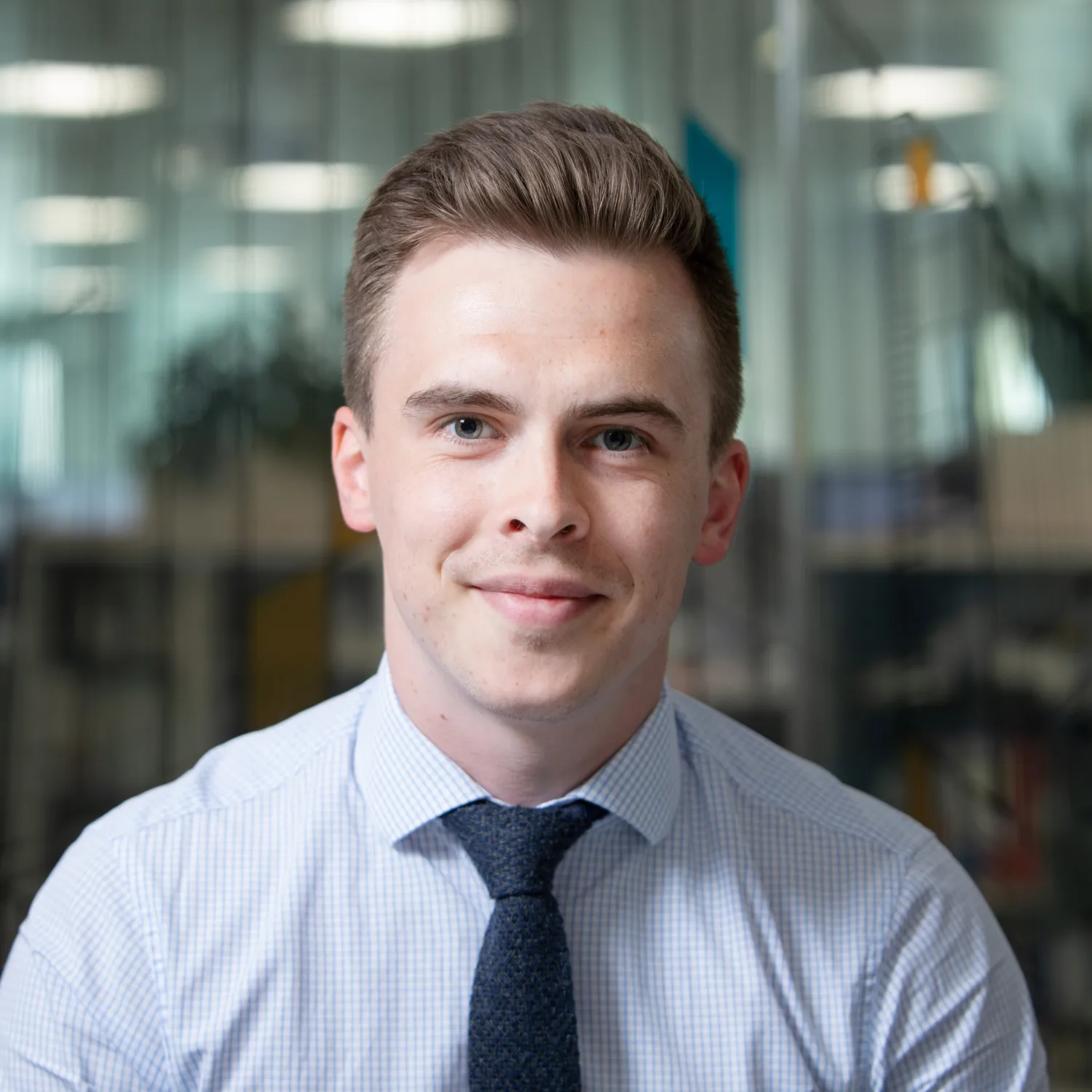 Dominykas sitting in office with shirt and tie on