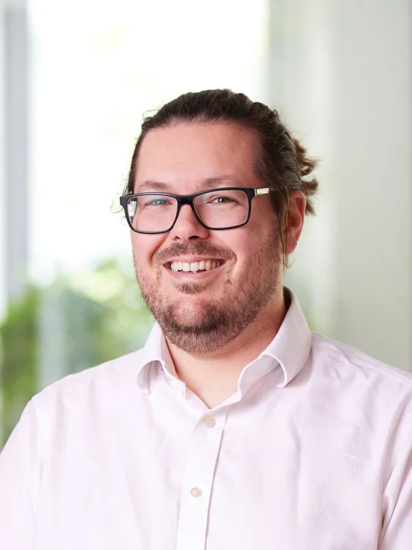 Head and shoulders image of Conrad Stone in an office wearing a white shirt