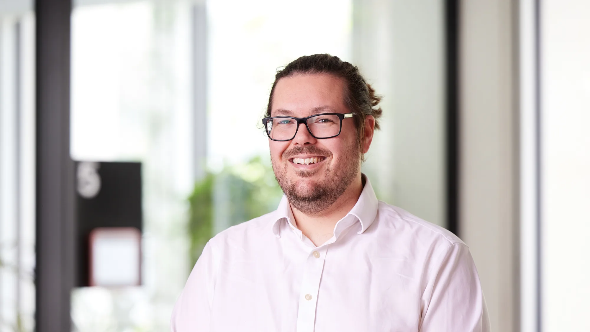 Head and shoulders image of Conrad Stone in an office wearing a white shirt