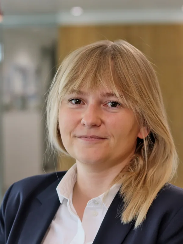 Gosia in a white open collar shirt and dark blue suit jacket