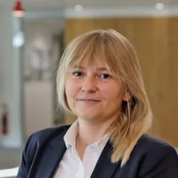 Gosia in a white open collar shirt and dark blue suit jacket