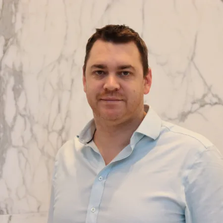 Jamie Cameron looking towards the camera in a light blue shirt