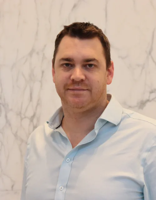 Jamie Cameron looking towards the camera in a light blue shirt