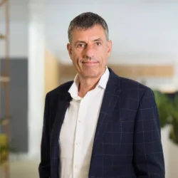 Peter Stocks in a suit and white shirt in front of stoage and office planting