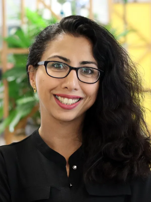 Roxana smiling to camera stood in an office space