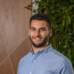 Seif wearing a blue shirt standing against a blurred background