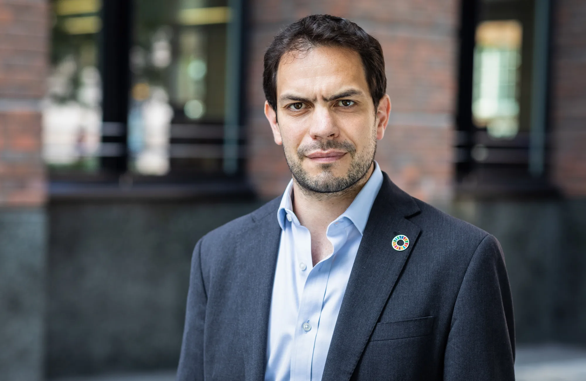 Simon Wyatt in front of office facade in a dark suit and blue shirt