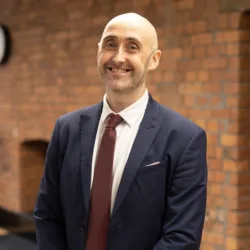 Gavin Bonner in office with brick background