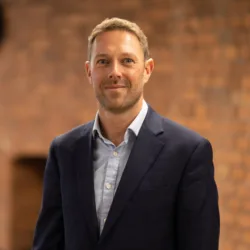 Lee Leston Jones in office with brick background