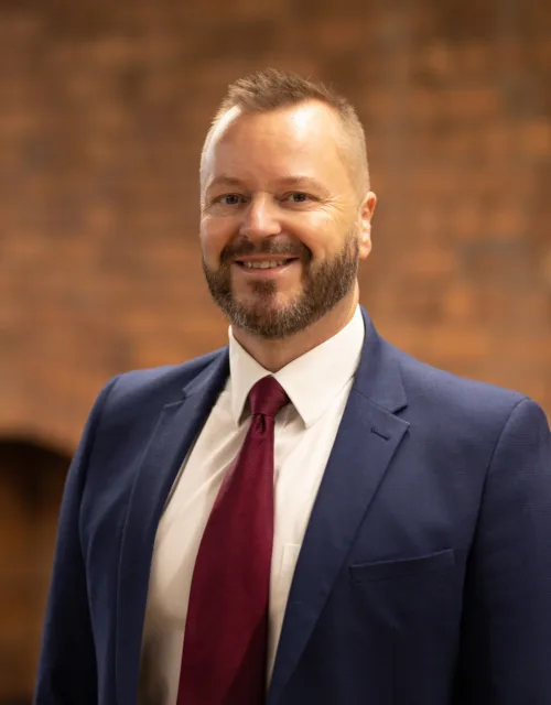Mark Moore in office with a brick background