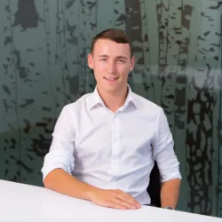 Carl Archer sitting upright on a desk