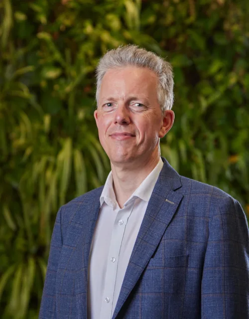 Duncan Cox stood in front of a green plant wall