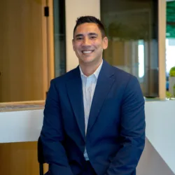 Faiyad Peterson in a blue suit sitting in the office