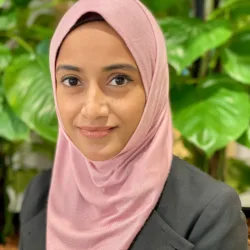 Anesah Begam posting for a photo while wearing her silky pink Hijab in our Singapore office