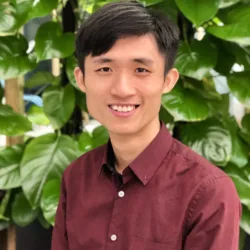 Qucheng Yan in a red shirt and planting in the background