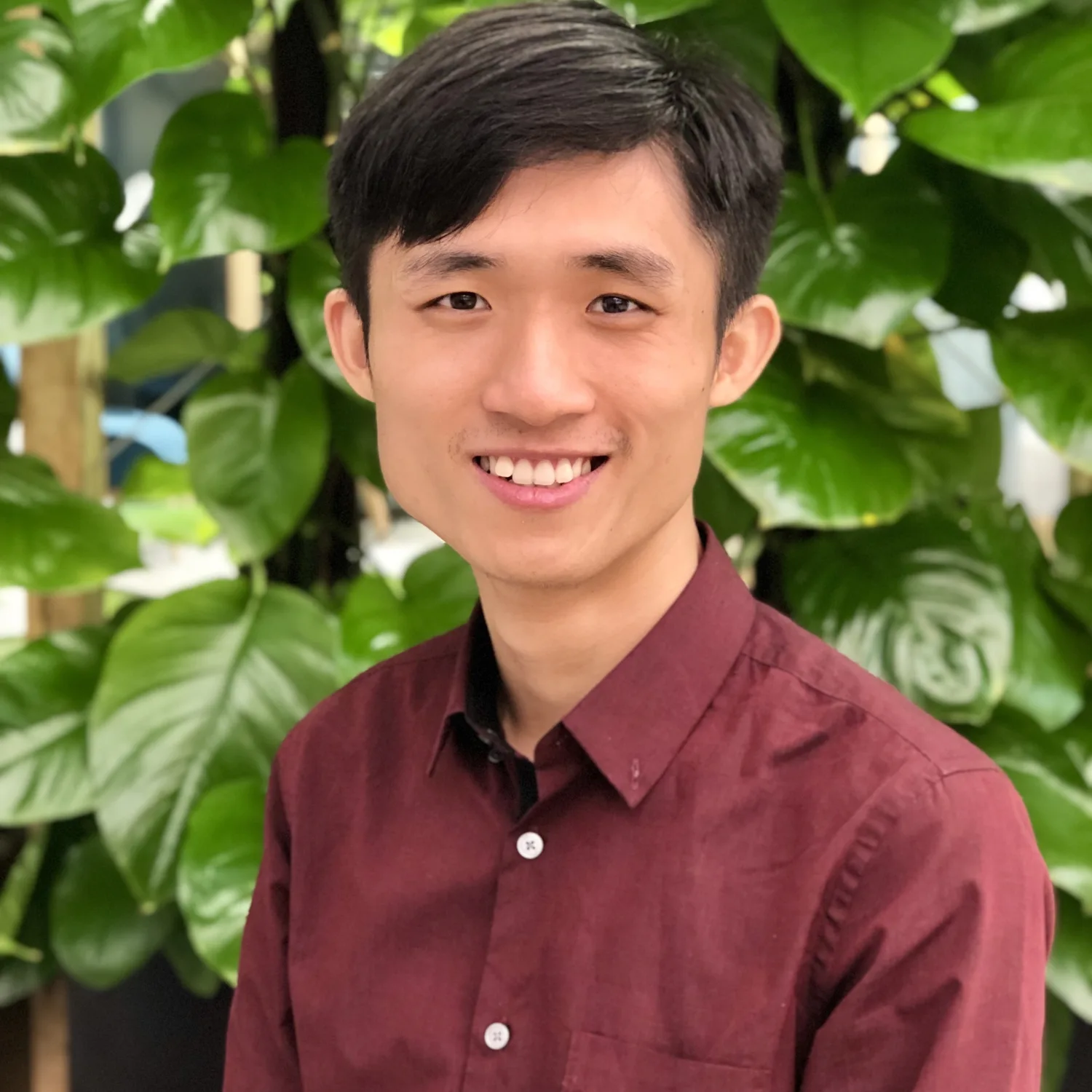 Qucheng Yan in a red shirt and planting in the background