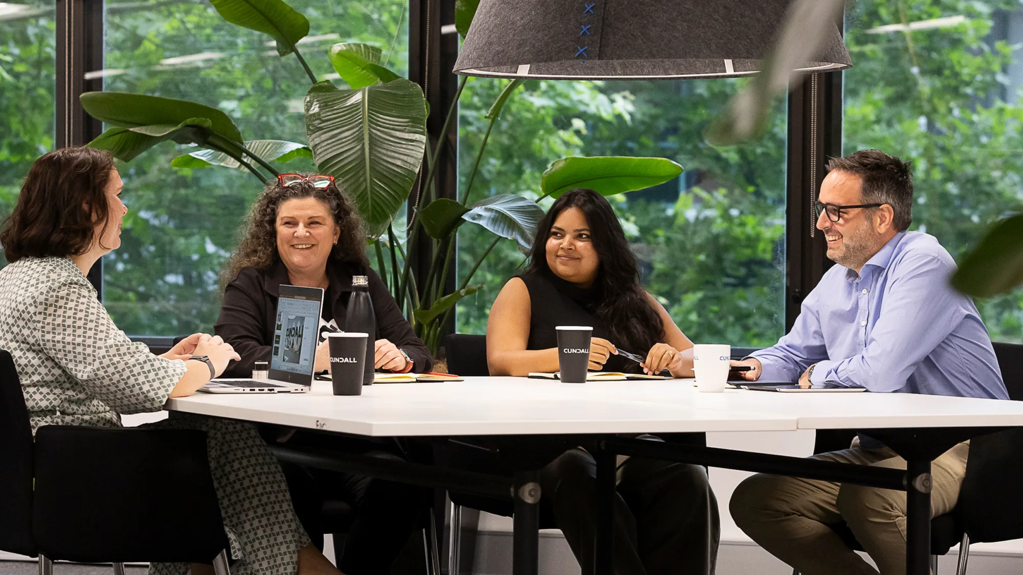 Julian sat at an office table with colleagues