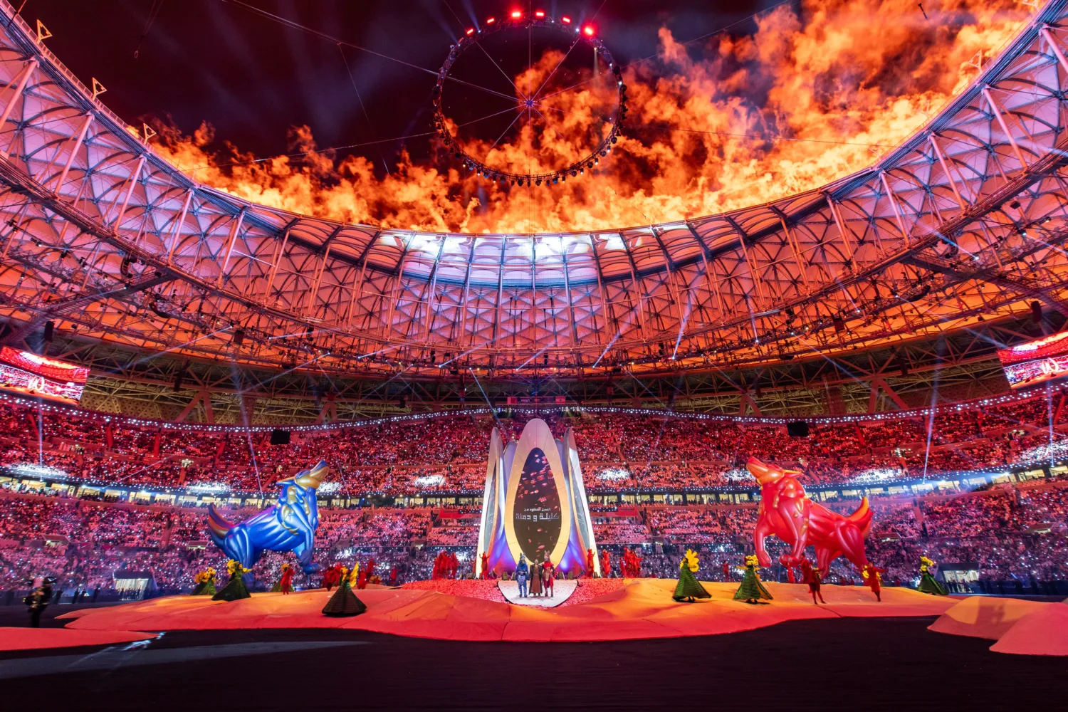 Snapshot of 2023 AFC Asian Cup Opening Ceremony with fires at the top and dancers and animal sculptures at the bottom