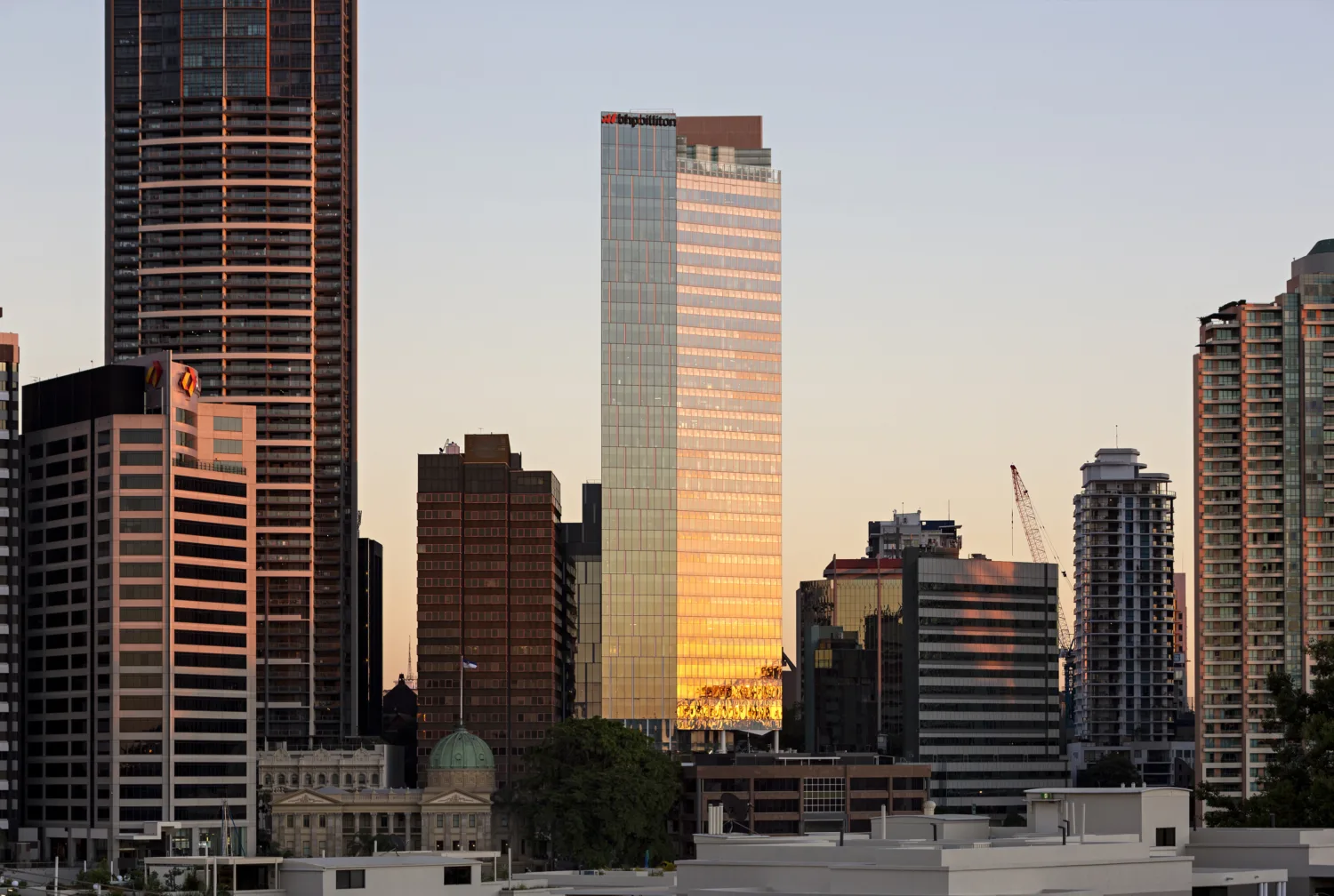 Brisbane skyline including 480 Queen Street illuminated by the setting sun.