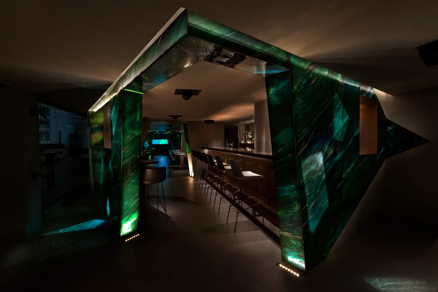 AOAO bar counter with spotlighting and wall is decorated with green gemstones.
