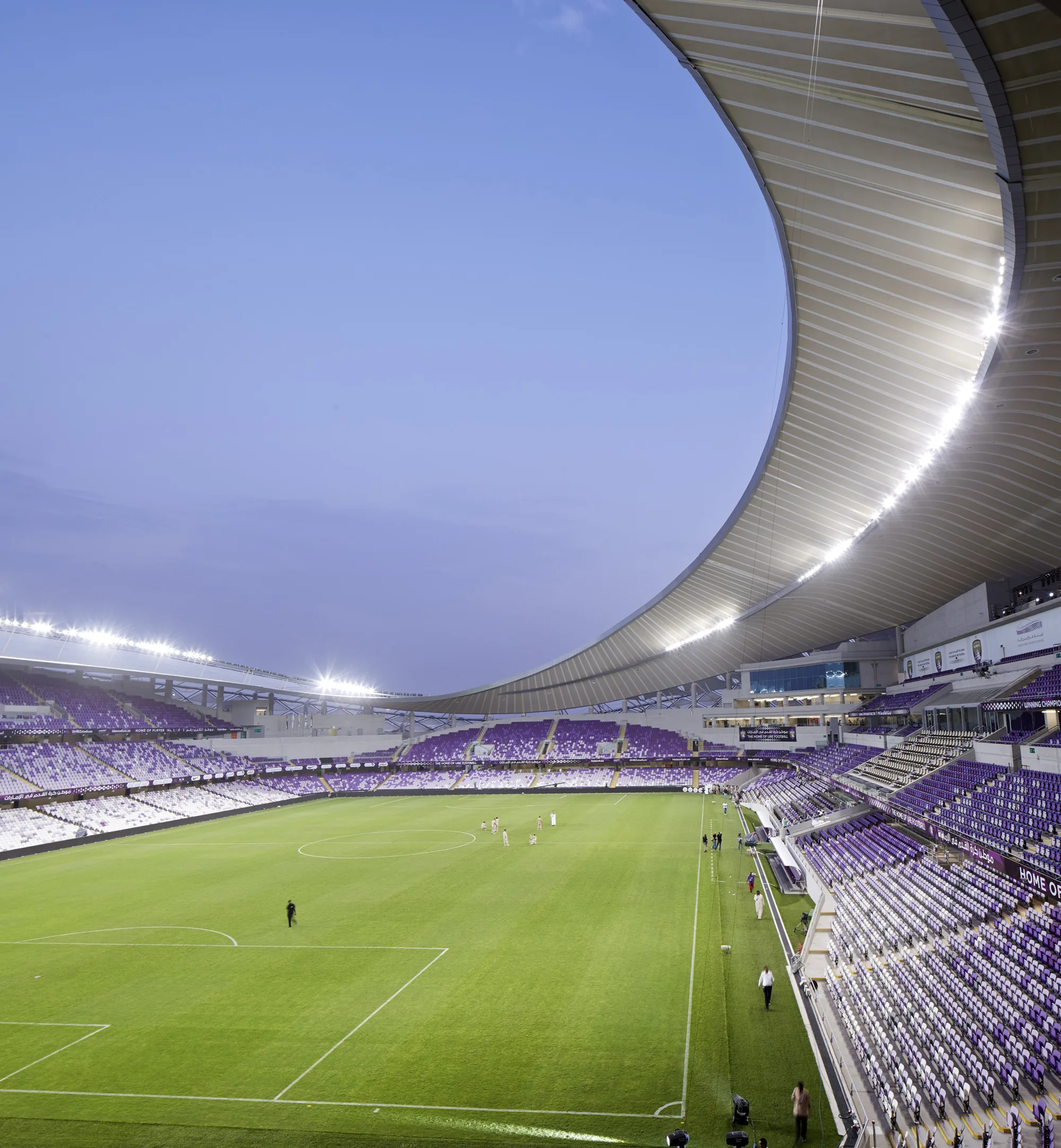 Internal shot of stadium at dusk showing pitch and stands