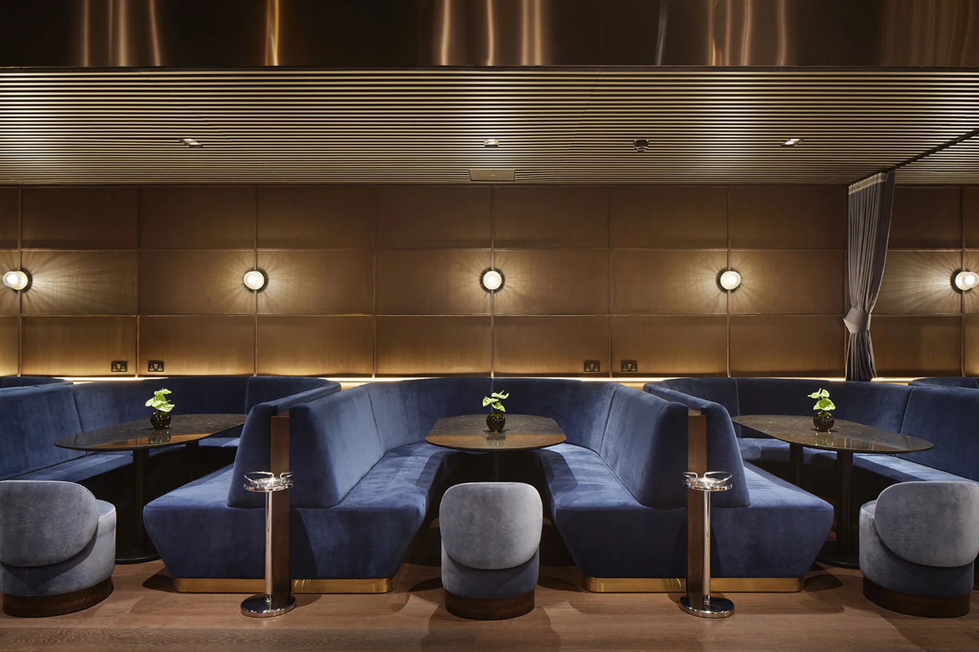 Bar seating booths with blue velvet seating and wooden tables