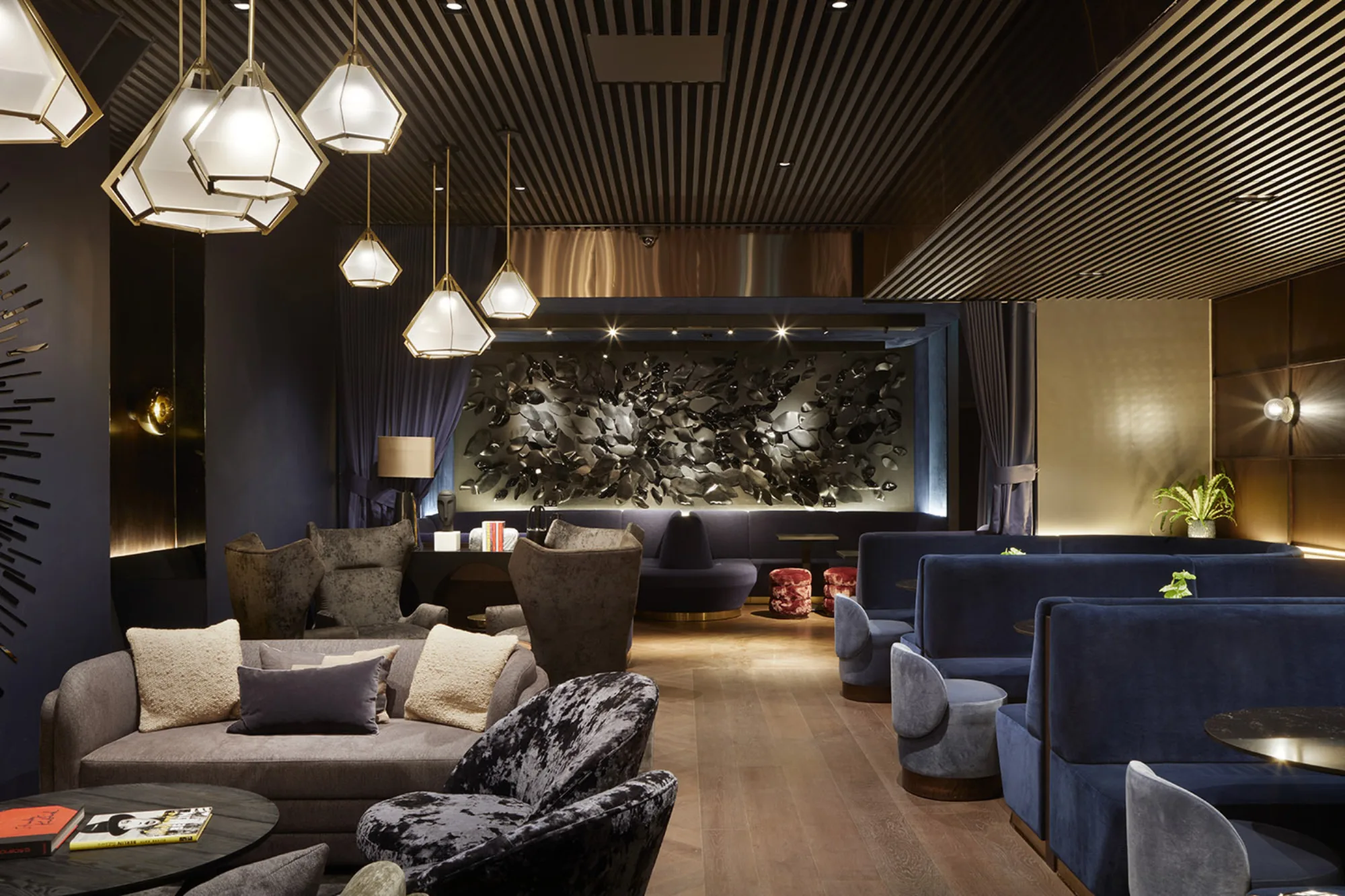 Hotel bar area with seating booths and low lighting with wooden ceilings