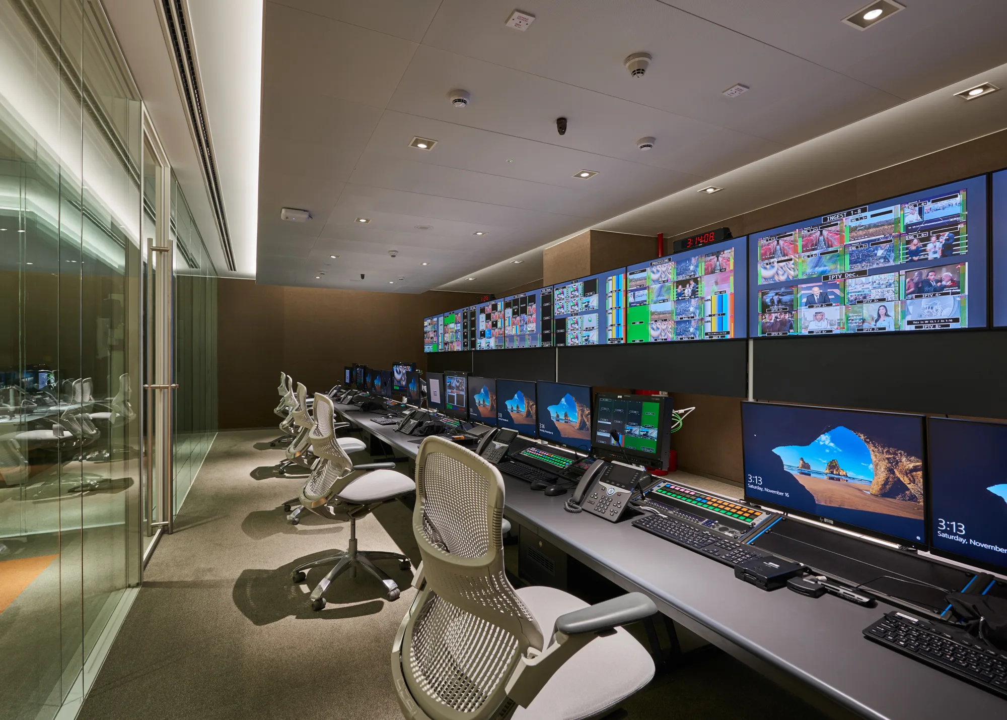 A room filled with desktop computers and ultra wide monitors dedicated for the television crew to control and monitor the scenes shown on tv at Ashraq News Services Dubai