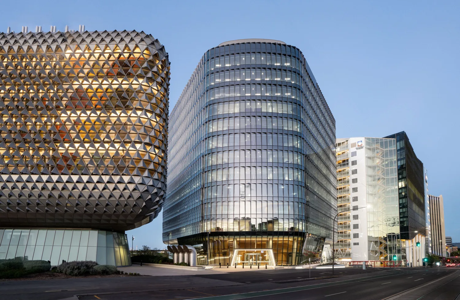 Exterior of a modern hospital building with a glass covered facade reflecting the sky