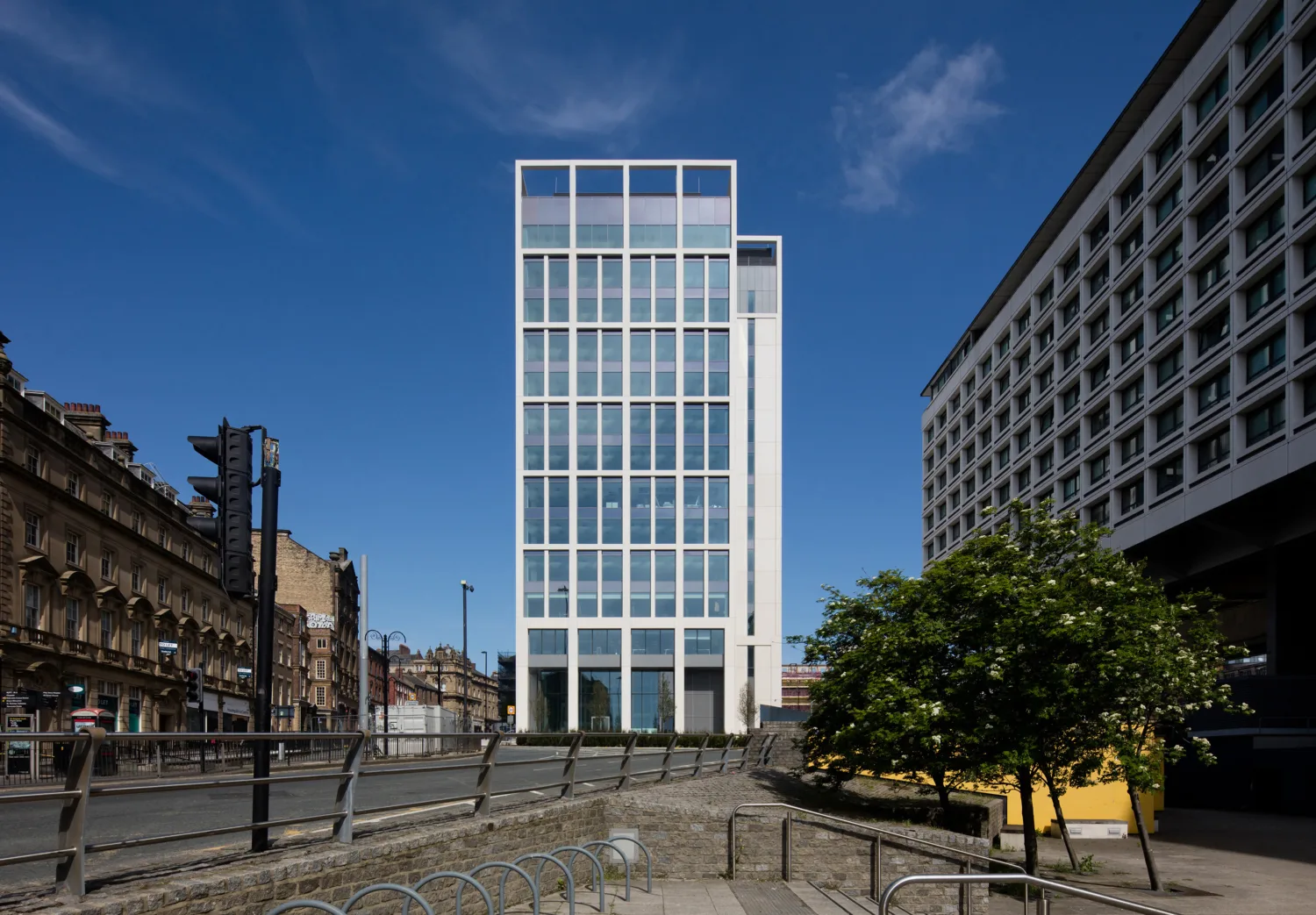 Building façade of glass and concrete with surrounding areas and blue sky