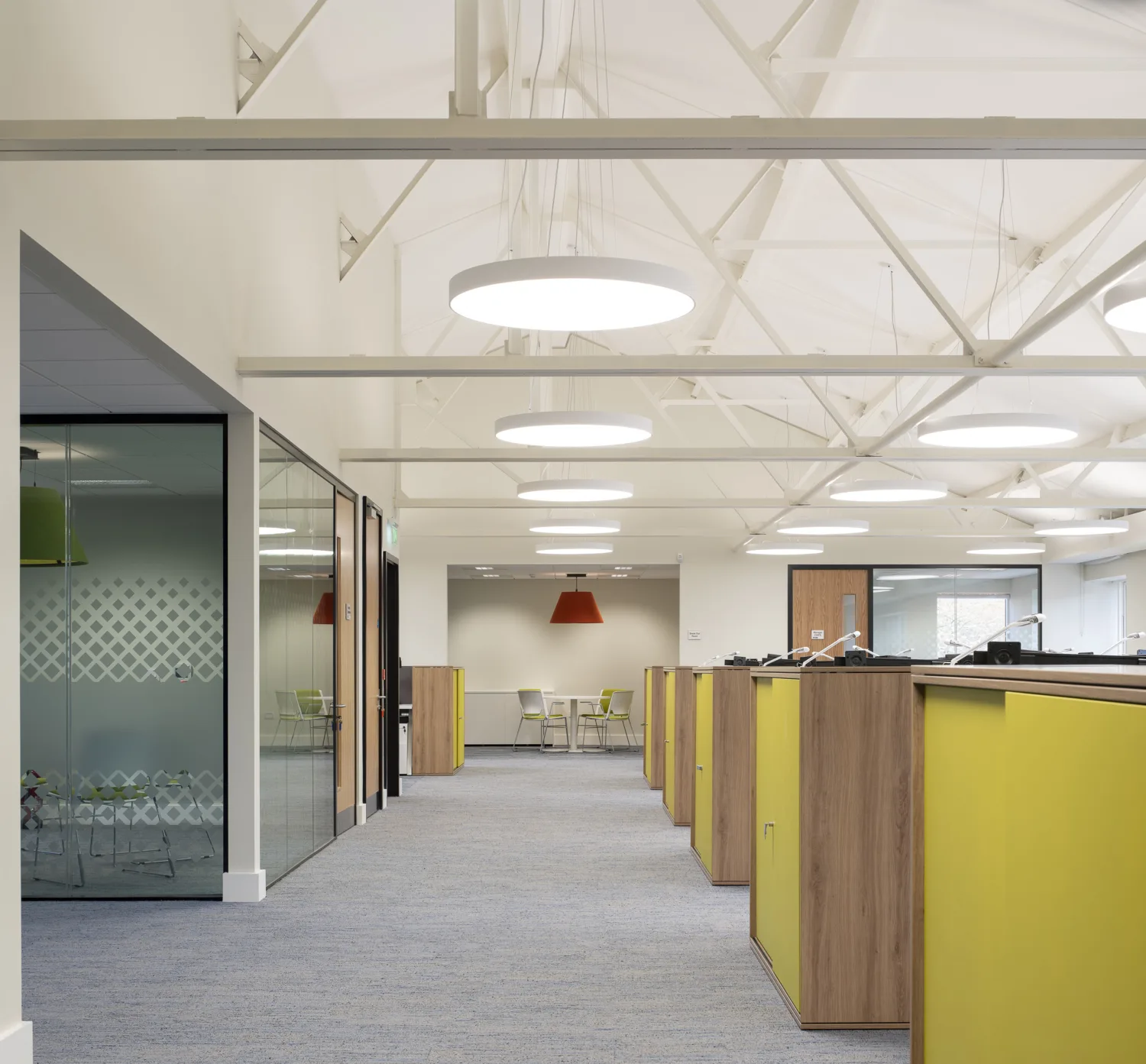 Open plan office with light walls and brightly coloured office area