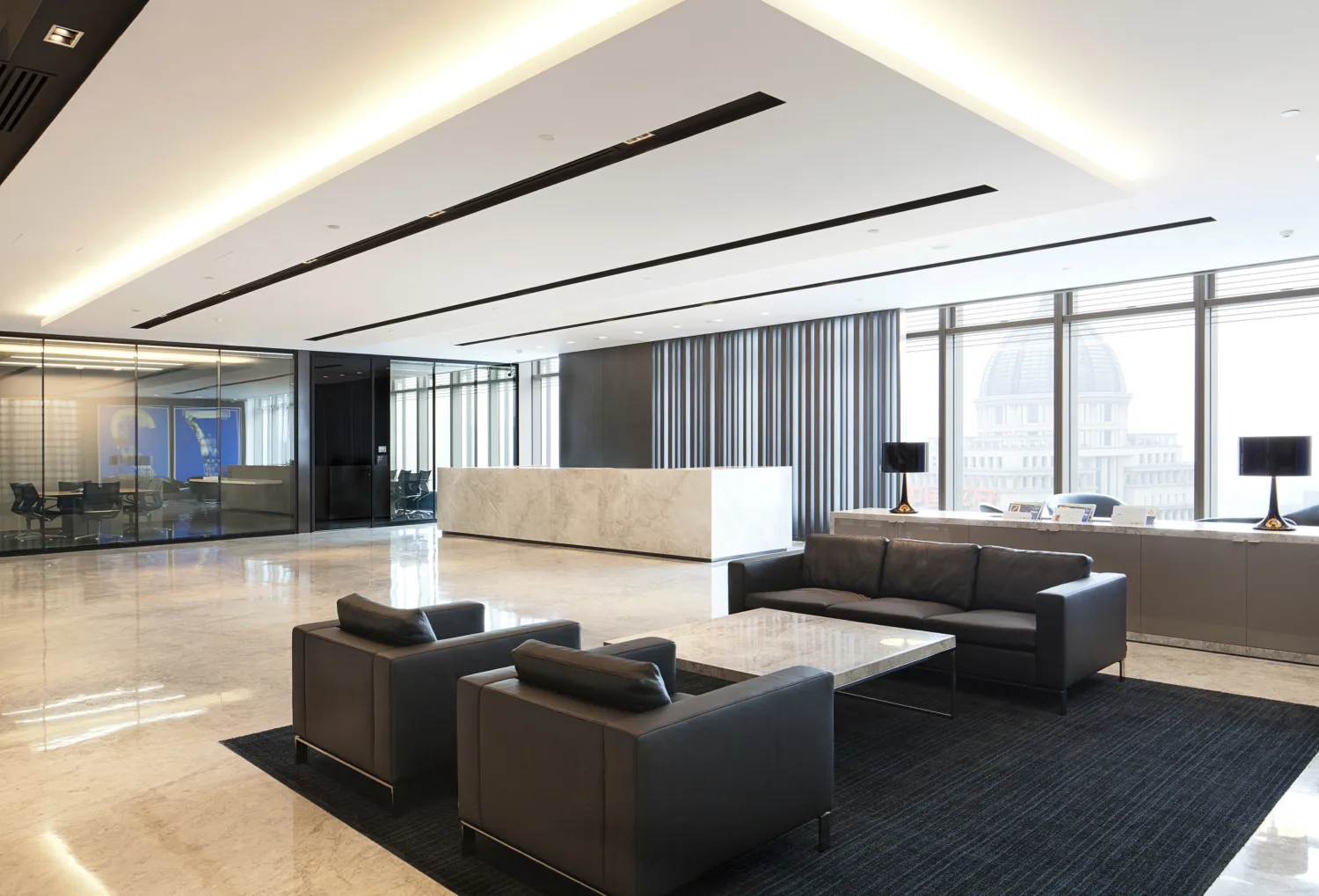 Brightly lit spacious reception area with marble floor featuring carpeted seating area and floor-to-ceiling windows
