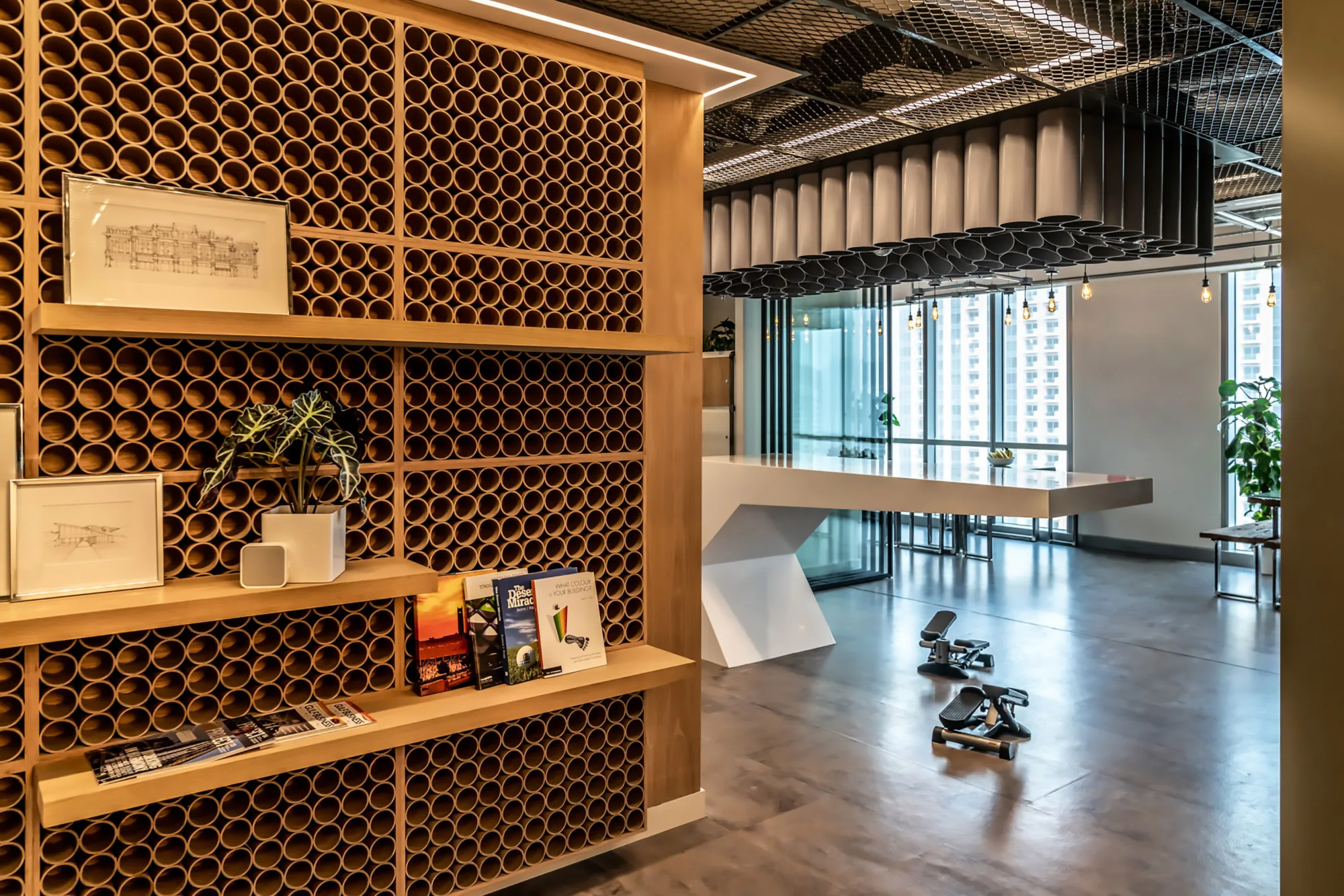 A view of Cundall Dubai WELL office achievements wall made out of recycled materials and the cantilevered table where meetings are conducted