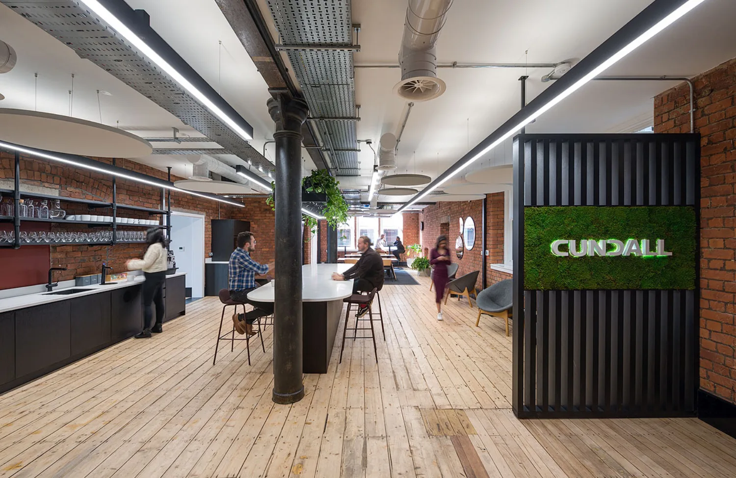 Wooden floor and brick walls in an open plan workspace in Cundall Manchester office