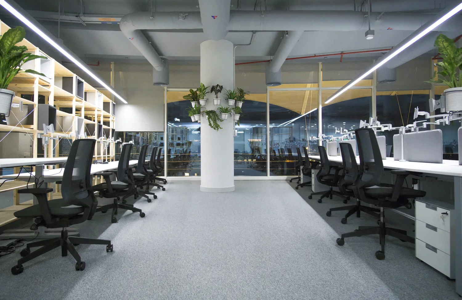 Night view of Cundall Qatar WELL office workstations with cupboards & plants