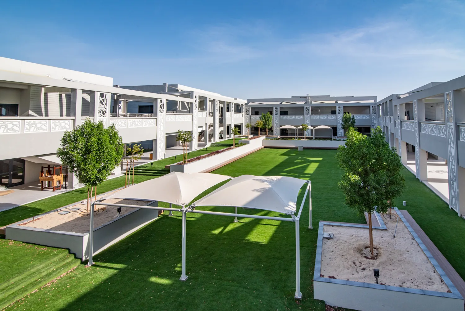 Doha College large central compound with green grass and trees