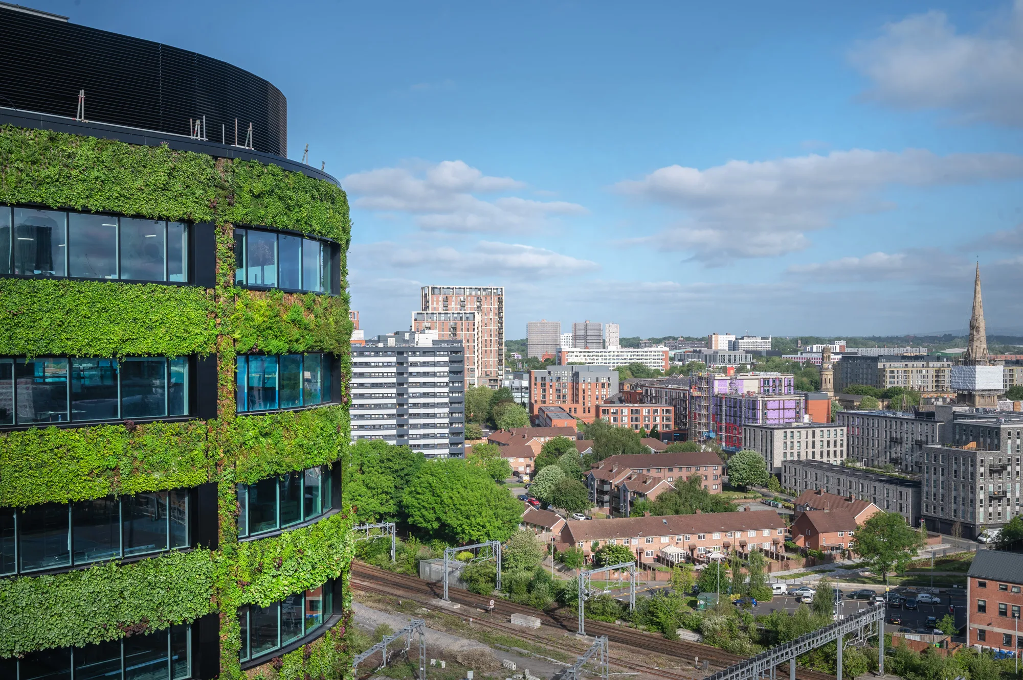 Green facade building with manchester skyline in background