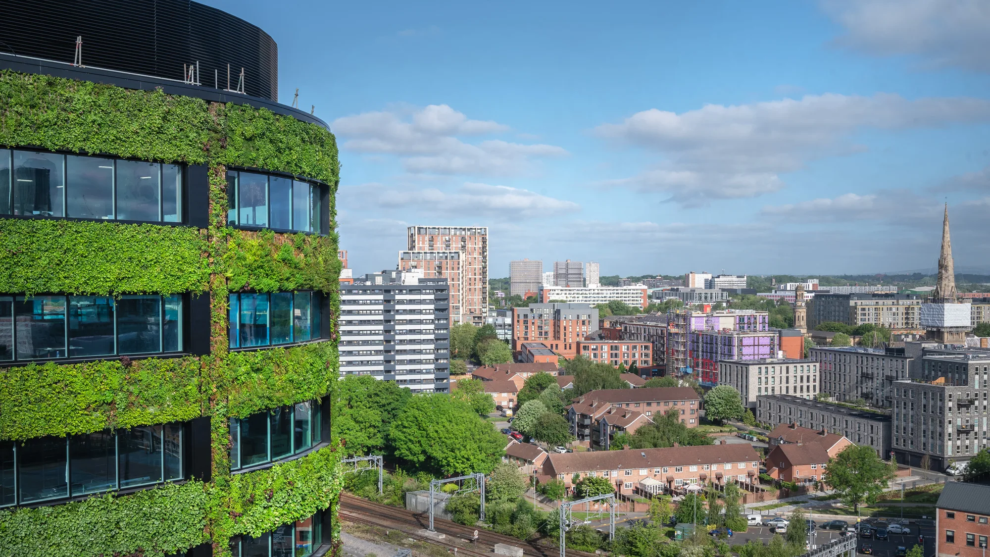 Green facade building with manchester skyline in background