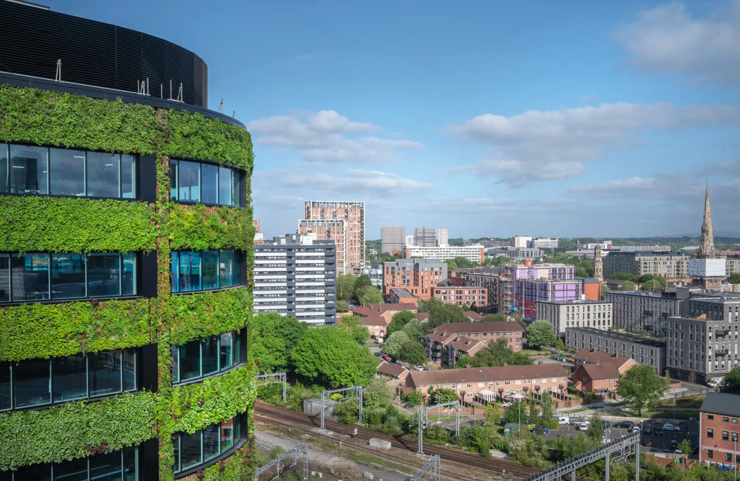 Green facade building with manchester skyline in background