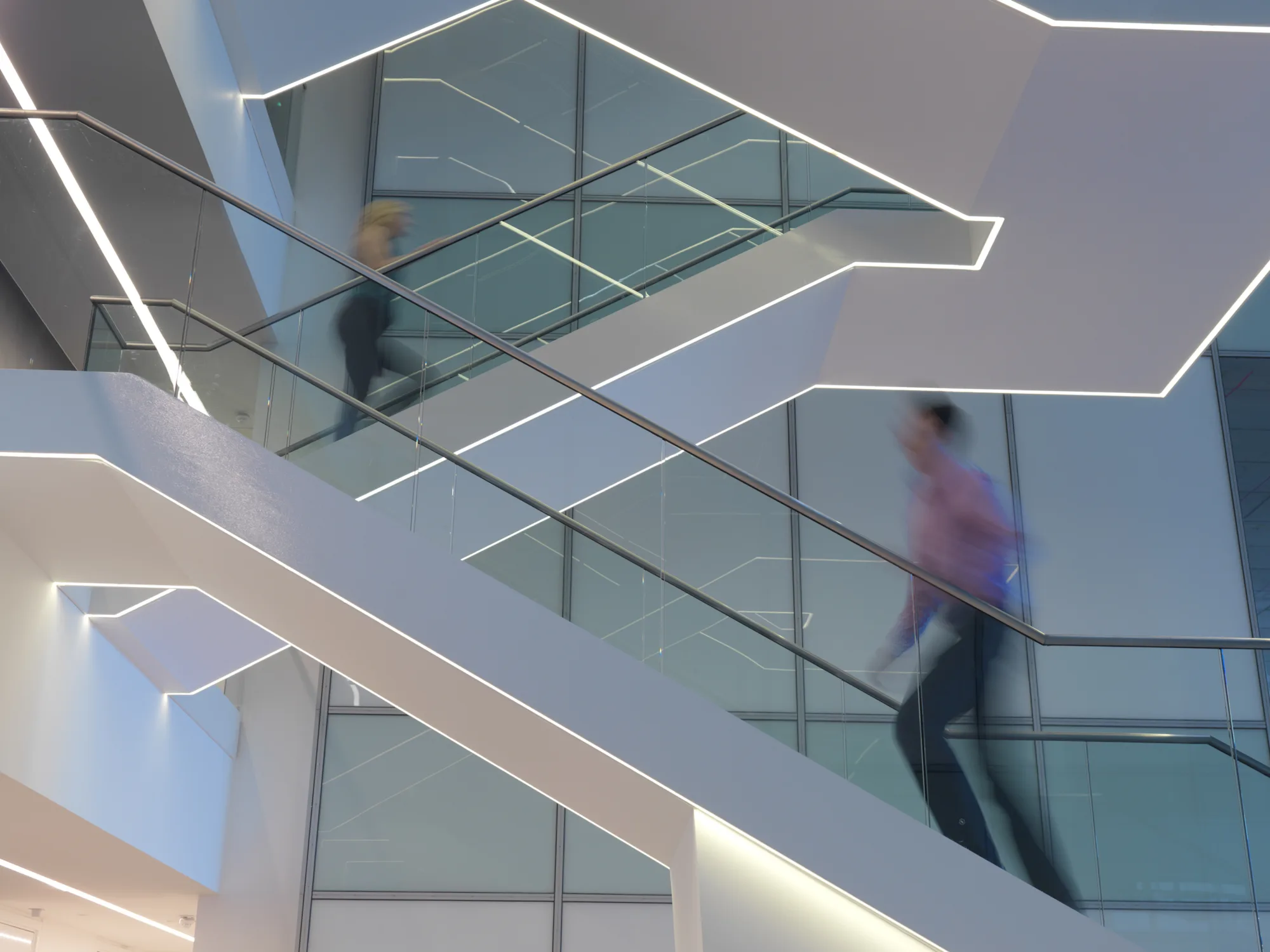 Staircase light in office atrium with staff walking up