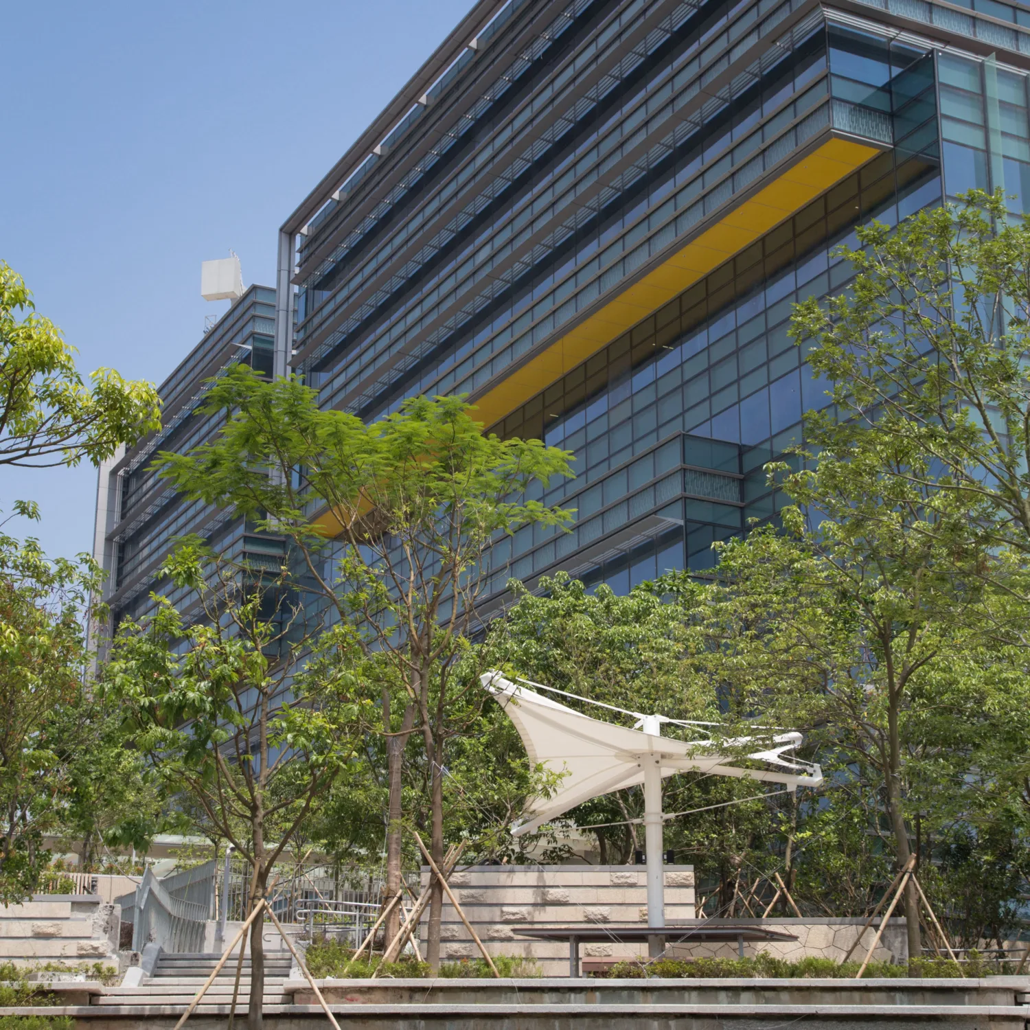 Exterior shot of the building in another angle, a stair with greenery beside is connected to the building