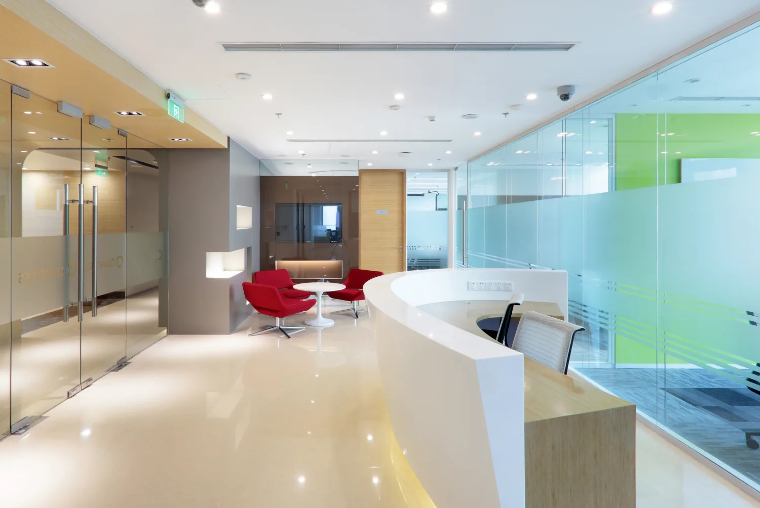 Reception area with marble flooring featuring reception counter, seating area, glass partitions separating it from main office area