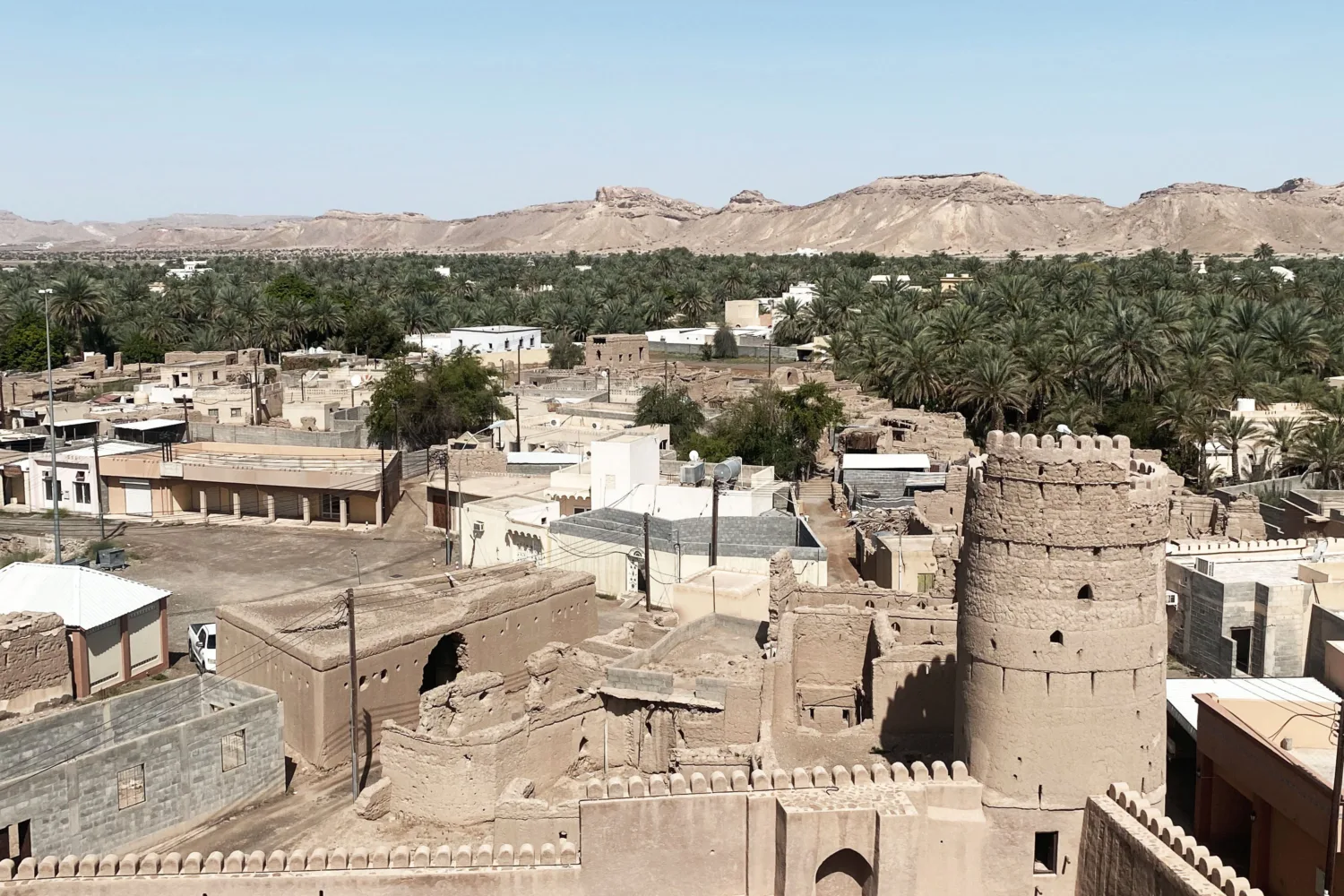 Heritage site situated beside a mountain, surrounded by palm trees.