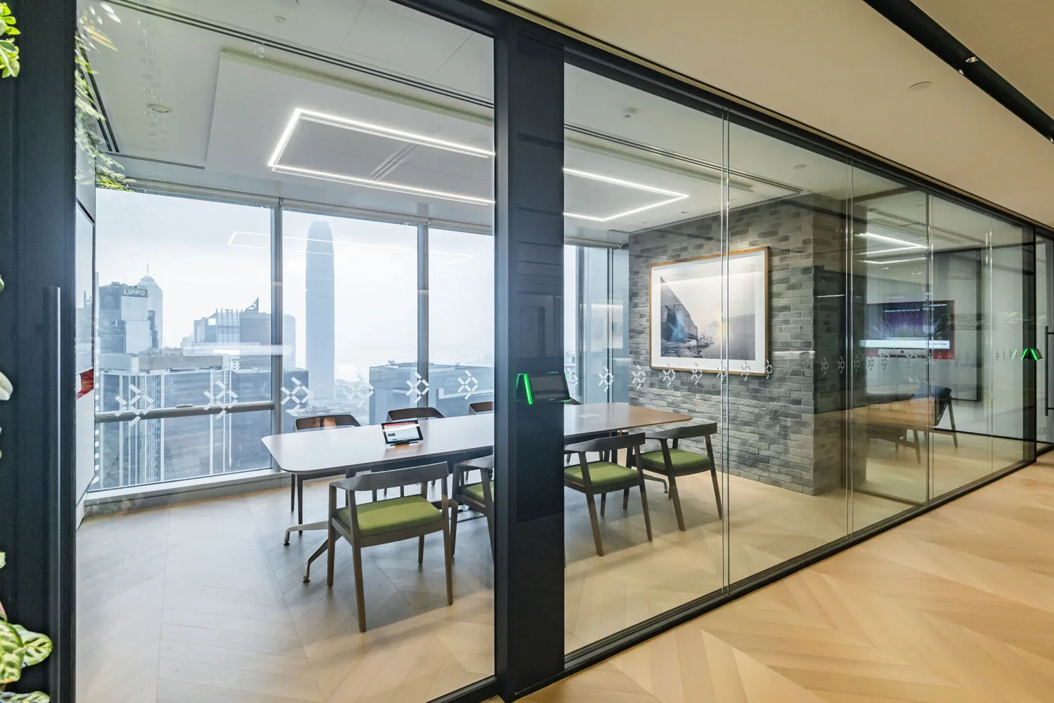 A glazed meeting room with a picture for decoration and ceiling lights design
