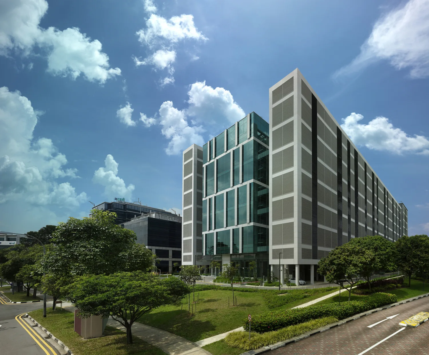 External view of six-storey data centre featuring tinted glass panels and surrounded by grassy fields
