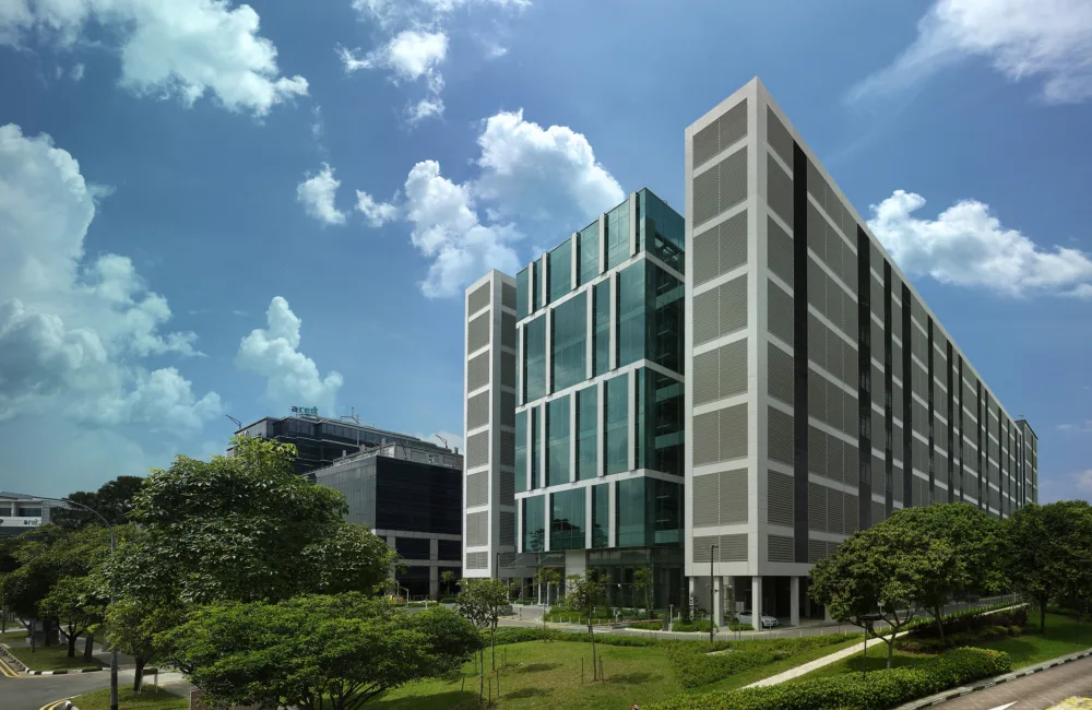 External view of six-storey data centre featuring tinted glass panels and surrounded by grassy fields
