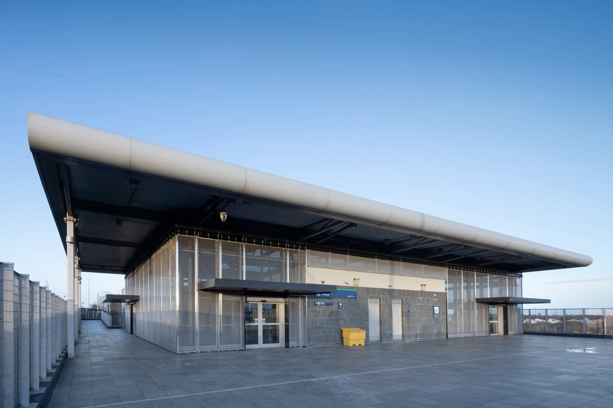 Exterior view of Kishoge station against a clear blue sky